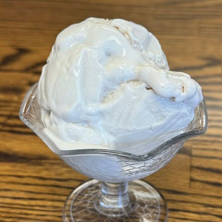 A scoop of homemade dairy-free vanilla ice cream in a footed glass dish