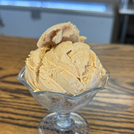 A scoop of homemade pumpkin pie ice cream in a footed glass dish